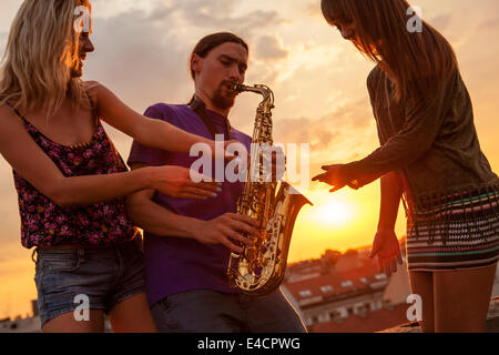 Jeune homme jouant du saxophone au coucher du soleil, Osijek, Croatie Banque D'Images