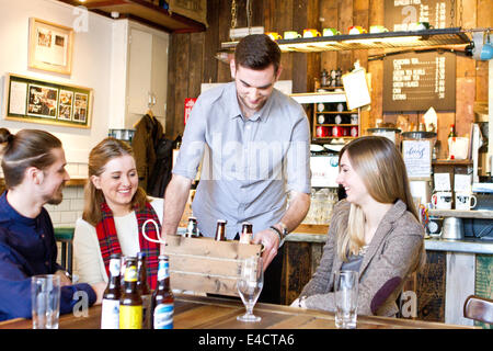 Jeune homme montre diverses marques de bière à des amis dans un pub, Dorset, Bournemouth, Angleterre Banque D'Images