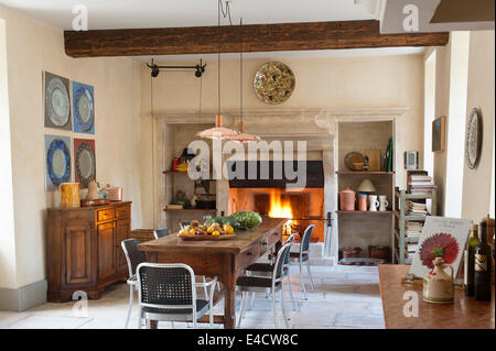 La cuisine provençale avec grande cheminée en pierre et table à manger en bois. La poignée de cuivre sont d'une conception et d'Arne Jacobsen Banque D'Images