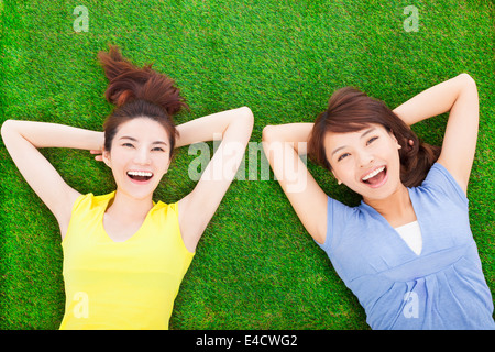 Deux smiling young woman lying on meadow Banque D'Images