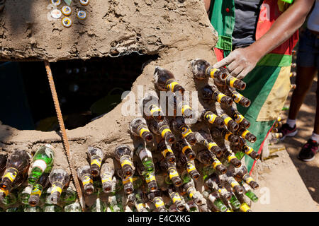 L'homme du Kenya La construction d'une hutte de terre à l'aide de bouteilles en verre et autres matériaux recyclés Banque D'Images