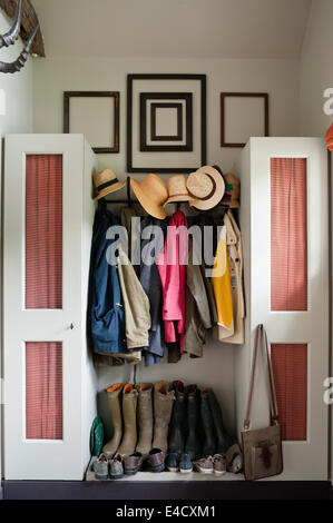 Manteaux, chapeaux et bottes dans un hall d'entrée avec placards de rangement Banque D'Images