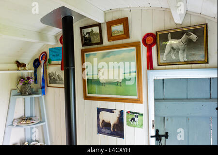 Un assortiment de photos et créations sur le thème des animaux sur le mur d'une cabane de bergers en bois. Banque D'Images