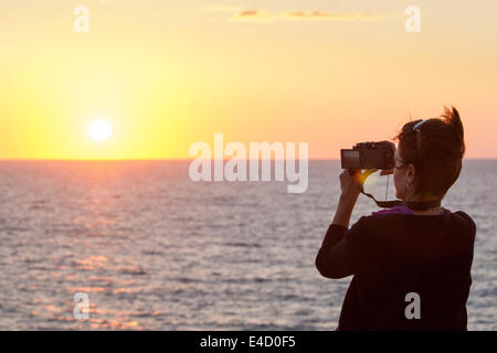 Un touriste photographie la coucher de soleil sur le Pacifique de Mazatlán, Sinaloa, Mexique. Banque D'Images