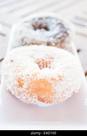 La vanille et noix de coco chocolat donuts servant sur plaque blanche, stock photo Banque D'Images