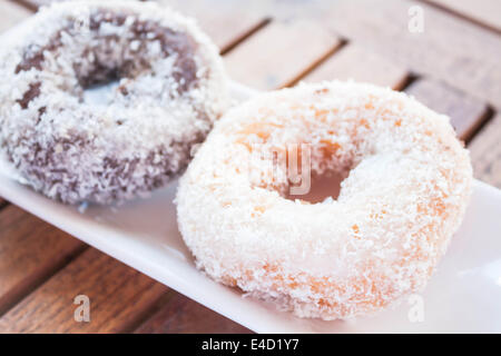 La vanille et noix de coco chocolat donuts sur table en bois, stock photo Banque D'Images