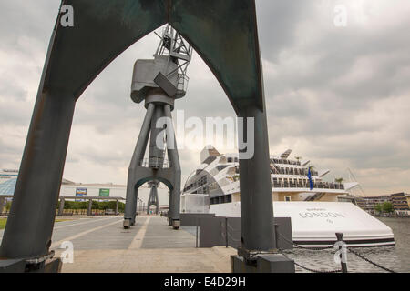 Vieux grues sur le quai de la Royal Victoria Dock, à Londres, à l'égard de Canary Wharf, avec le bateau yacht hôtel Sunborn. Banque D'Images