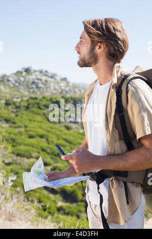 Handsome hiker holding la carte et boussole à la montagne Banque D'Images