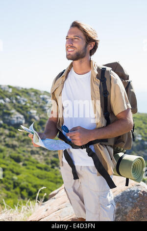 Handsome hiker holding la carte et boussole à la montagne Banque D'Images