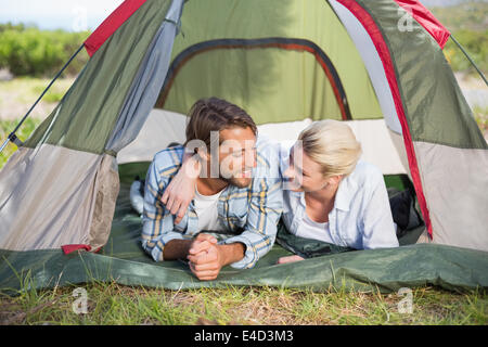 Beau couple couché dans leur tente smiling at each other Banque D'Images