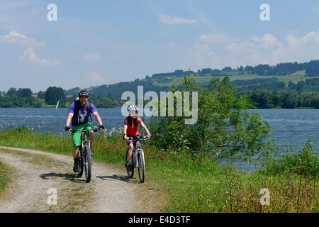 Le père et l'enfant sur un vélo tour à Rottachspeicher Rottachsee, réservoir, lac Oberallgäu, souabe, Bavière, Allemagne Banque D'Images