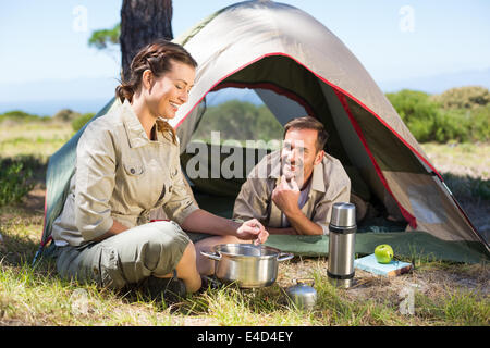 Couple de plein sur la cuisine cuisinière camping tente l'extérieur Banque D'Images