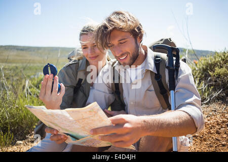 Deux randonnées en faisant une pause sur le terrain de montagne à l'aide de la carte et boussole Banque D'Images