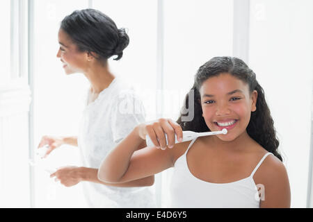 Jolie mère se brosser les dents avec sa fille Banque D'Images