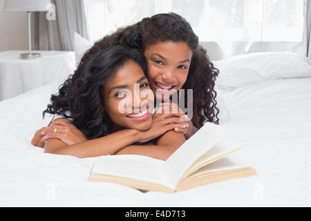 Mother and Daughter reading book together on bed Banque D'Images