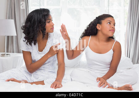 Mère et fille ayant un argument on bed Banque D'Images