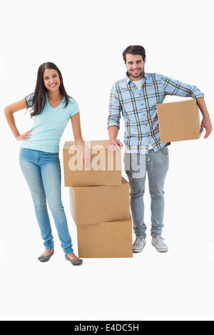 Attractive young couple with moving boxes Banque D'Images