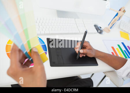 Designer travaillant au bureau à l'aide d'échantillon de couleur et du numériseur Banque D'Images