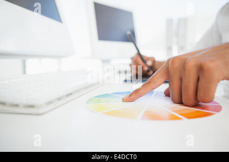 Designer travaillant au bureau à l'aide d'une roue des couleurs Banque D'Images