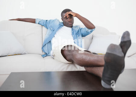 Casual man sitting on sofa avec pieds Banque D'Images