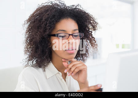 Pretty casual businesswoman working at desk Banque D'Images