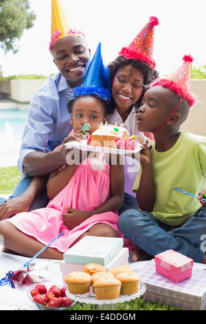 Famille heureuse de célébrer un anniversaire ensemble dans le jardin Banque D'Images