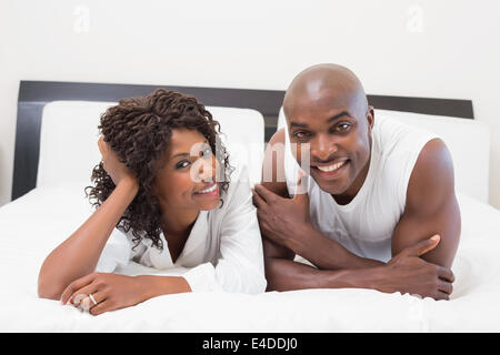 Heureux couple lying on bed together Banque D'Images