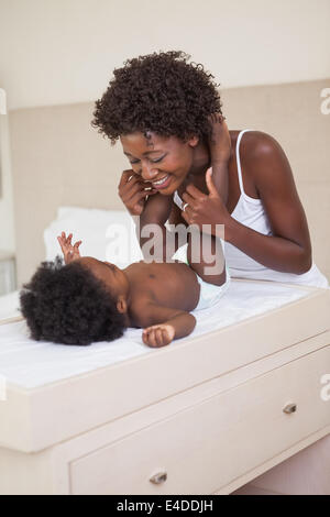 Happy mother with baby girl sur table à langer Banque D'Images