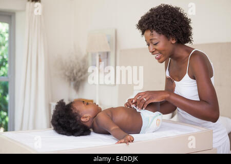 Happy mother with baby girl sur table à langer Banque D'Images