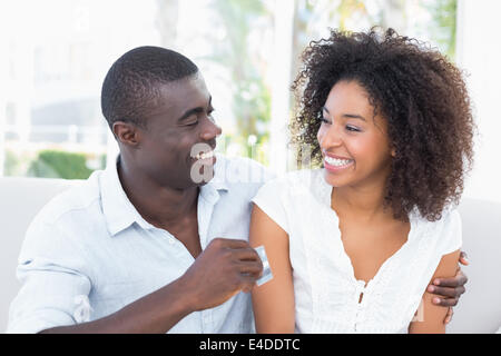 Beau couple sitting on couch ensemble holding credit card Banque D'Images