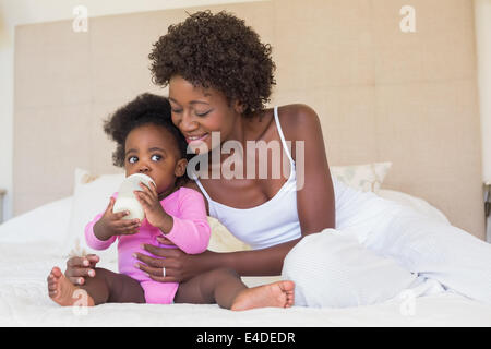 Heureux parents avec bébé fille sur leur lit Banque D'Images