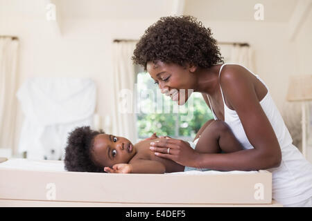 Happy mother with baby girl sur table à langer Banque D'Images