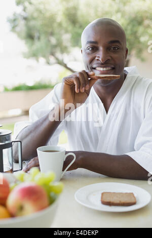 Bel homme en peignoir de prendre le petit déjeuner à l'extérieur Banque D'Images