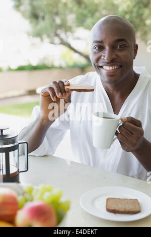 Bel homme en peignoir de prendre le petit déjeuner à l'extérieur Banque D'Images