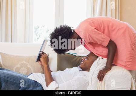 Cute couple relaxing on couch with tablet pc Banque D'Images