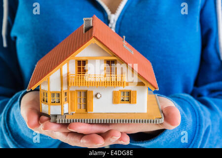 Hands holding miniature house model Banque D'Images