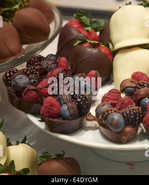Les framboises et les mûres bleuets dans le chocolat Les paniers sont affichées avec des fraises enrobées de chocolat Banque D'Images
