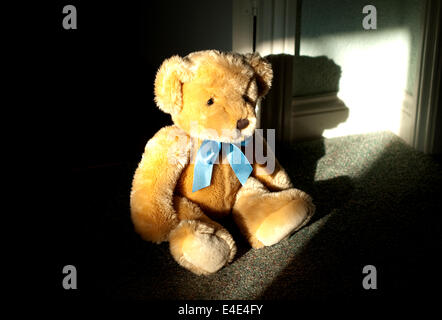 Still Life concept image d'un ours en peluche de l'enfant assis dans l'ombre d'une porte Banque D'Images