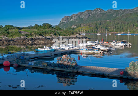 Bateaux amarrés et le homard à la nasse empilés sur des jetées de port, Plockton Loch Carron, Wester Ross, les Highlands écossais Ecosse UK Banque D'Images