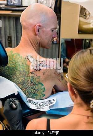 Femme tatouage un aigle sur le dos d'un homme Banque D'Images