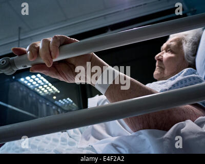 CORONAVIRUS Old Old Old Old Lady Covid-19 Hospital inquiétait une dame âgée âgée âgée retraité dans le lit d'hôpital la nuit tenant le lit en premier plan Banque D'Images