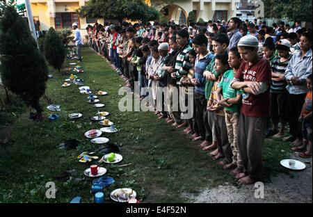 (140710) -- Srinagar, 10 juillet 2014 (Xinhua) -- les orphelins musulmans du Cachemire offrent des prières après l'iftar, repas du soir lorsque les musulmans rompre leur jeûne durant le mois du Ramadan islamique, dans un orphelinat "Jammu-et-Cachemire Yateem confiance' à Srinagar, la capitale d'été du Cachemire sous contrôle indien, le 9 juillet 2014. Bien qu'il y a des statistiques sur le nombre d'enfants orphelins dans le Cachemire sous contrôle indien, le gouvernement local estime qu'il y a plus de 8 000 enfants qui vivent dans des orphelinats, beaucoup d'entre eux devenus orphelins à cause du conflit armé qui a commencé en 1989 dans la région. (Xinhua/Javed Dar) Banque D'Images