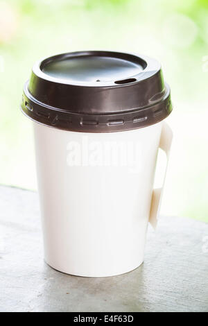 Café chaud tasse de papier avec green bokeh Banque D'Images