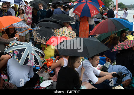 Pique-nique à la pluie un été anglais temps humide 2010 Henley Royal Regatta des foules de spectateurs bordent les rives et abritent leurs parapluies. ROYAUME-UNI 2014 HOMER SYKES Banque D'Images