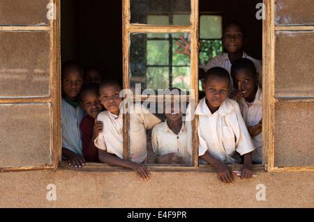 Portrait de groupe d'enfants d'une école éloignée en Tanzanie, l'Afrique en regardant par la fenêtre Banque D'Images