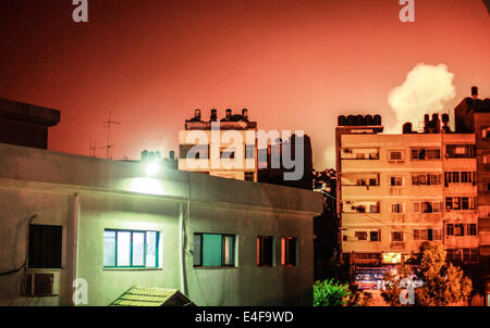 Gaza, la Palestine. 09 juillet 2014. La fumée s'élève des bâtiments après une frappe aérienne israélienne dans la bande de Gaza, le 9 juillet 2014. L'aviation israélienne a pilonné Gaza aujourd'hui, tuant au moins 24 personnes dans un nouvel affrontement avec les militants palestiniens, que le Hamas a plié sa puissance de feu et a envoyé des milliers d'exécution pour les abris à travers le pays. Credit : Hosam Salem/NurPhoto/ZUMA/Alamy Fil Live News Banque D'Images