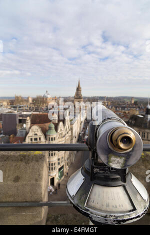 UK, Oxford, vue du haut de la tour Carfax vers le bas de la rue principale avec un télescope d'affichage au premier plan. Banque D'Images