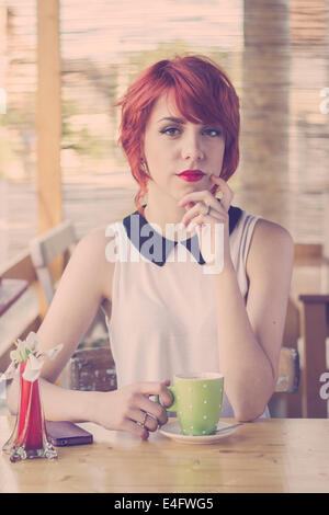 Cute young girl hippie dans un café, en compagnie de ses Banque D'Images