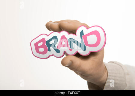 Une main tenant le mot marque sur un fond blanc. L'identité de l'entreprise concept. l'image est une composition entre 3d renderi Banque D'Images