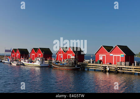 Les bateaux de pêche amarrés devant rouge de cabanes de bois dans le port de Boltenhagen le long de la mer Baltique, Mecklenburg-Vorpommern, Allemagne Banque D'Images